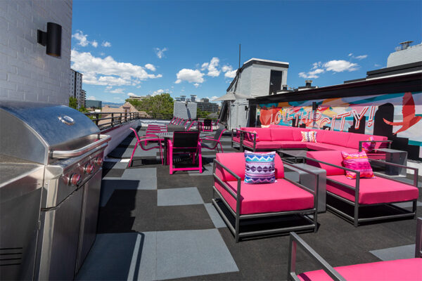 Rooftop patio with outdoor couches, built in BBQ grill, and mural art.