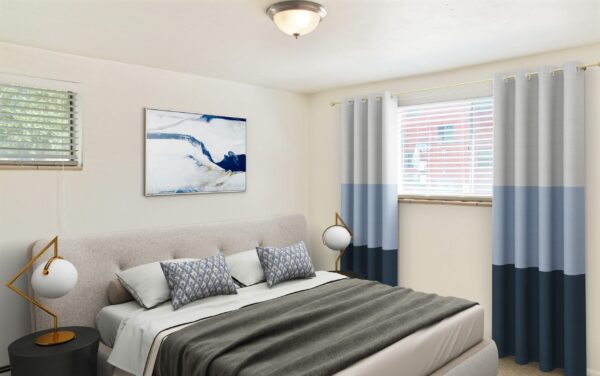 Bedroom with plush bed, bedside tables with lamps, framed artwork, and large windows.