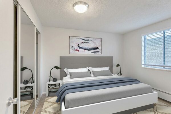 Bedroom with plush bed, bedside tables with lamps, and large window.