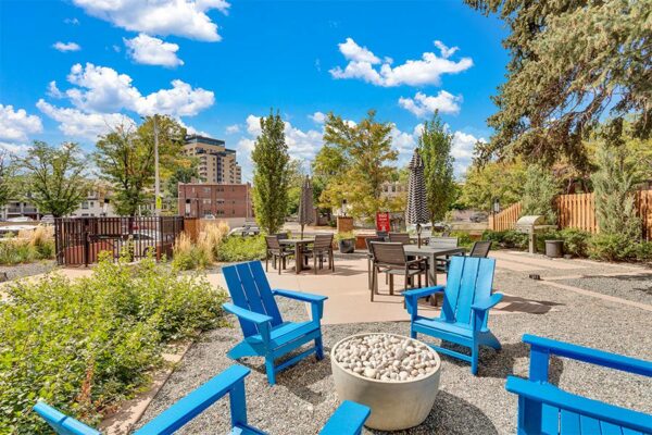 960 Grant patio with pavers, blue lounge chairs, lush landscaping, and tall trees.