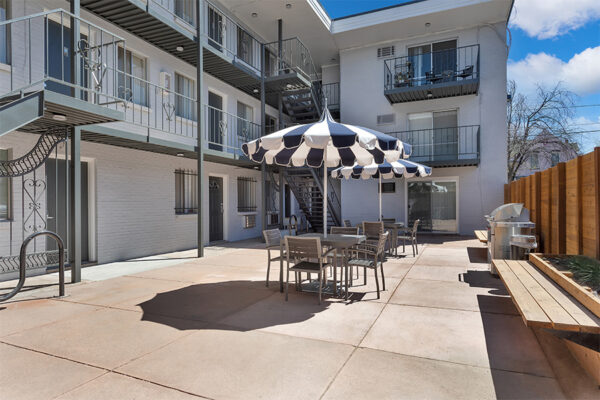 960 South Logan courtyard with umbrellas, tables, benches and BBQ grill.