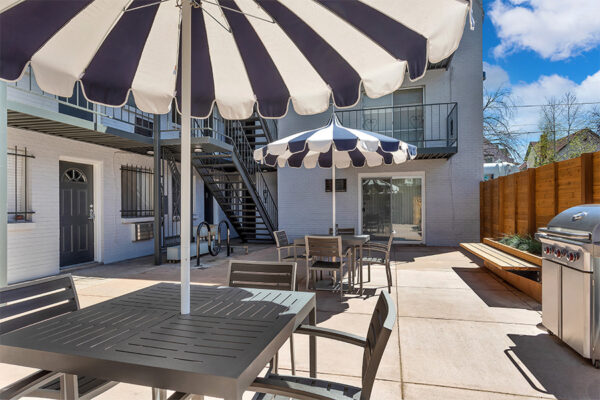 960 South Logan courtyard with umbrellas, tables, benches and BBQ grill.