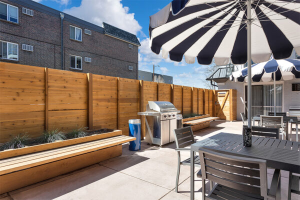 960 South Logan courtyard with umbrellas, tables, benches and BBQ grill.