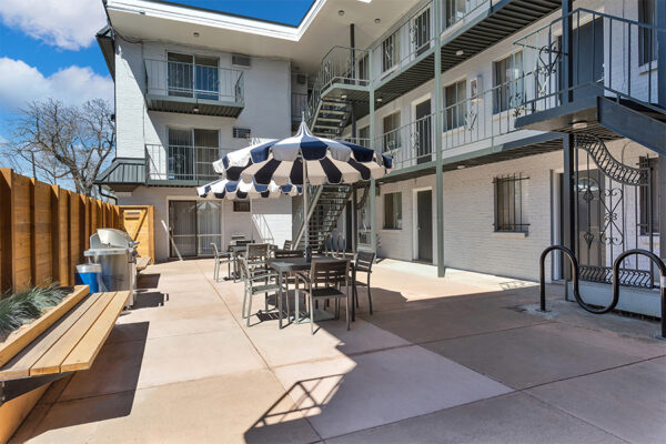 960 South Logan courtyard with umbrellas, tables, benches and BBQ grill.