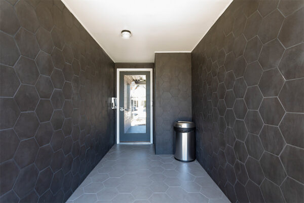 960 South Logan hallway with hexagon tiled walls and glass door.