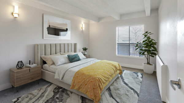 Bedroom with carpet, large rug, bed with plush headboard, artwork, and large window.