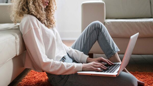 Woman on computer in apartment living room.