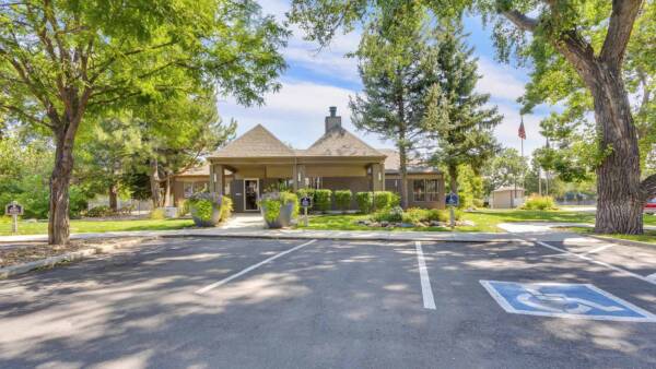 Cottonwood Creek clubhouse with lush green landscaping, mature trees, and ample parking.
