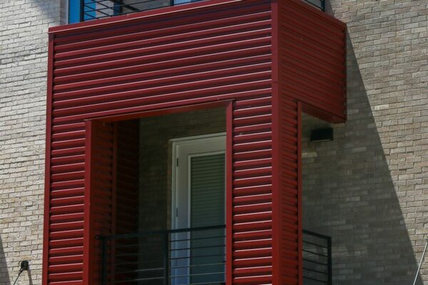 Dayton Station townhomes with brick construction, red metal siding, and balcony.