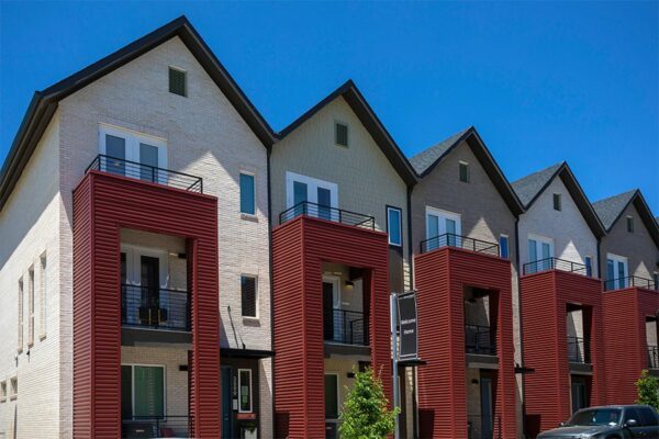 Three story Dayton Station townhomes with brick construction, red metal siding, and balconies.