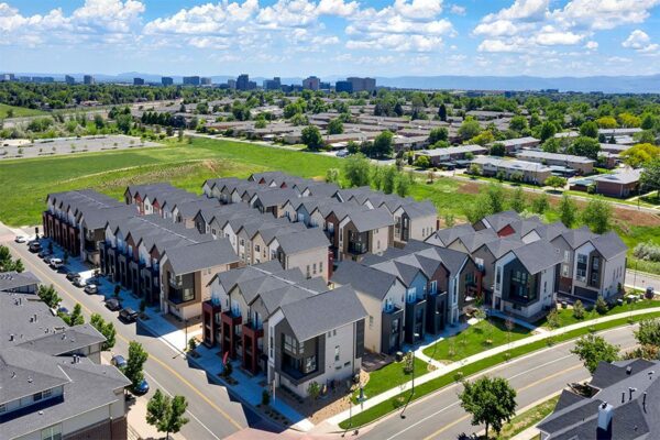 Aerial view of Dayton Station townhomes with nearby houses and distant foothills.