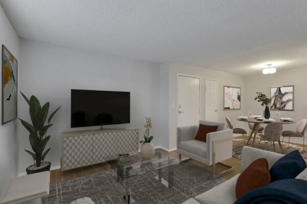 Living room with a rug over wood floors and white walls.