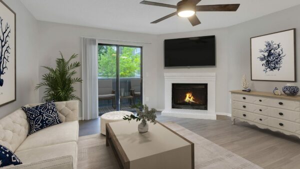 Living room with couch and side table with plants, fireplace and decor.