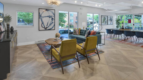 Lounge with wood floor, plush seating, eclectic modern decor, and large windows.