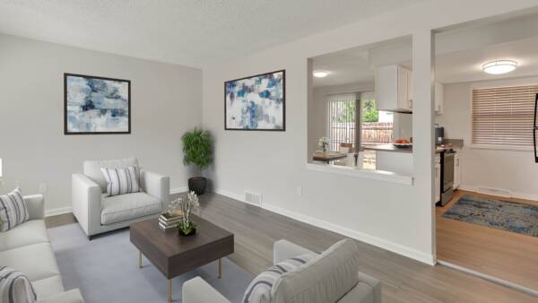 Kitchen and dining room with wood cabinets, white counters, modern dining table with chairs and large artwork.