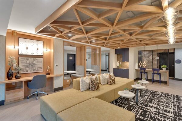 Lounge with large sectional couch, built in desk with chair, and modern booths.