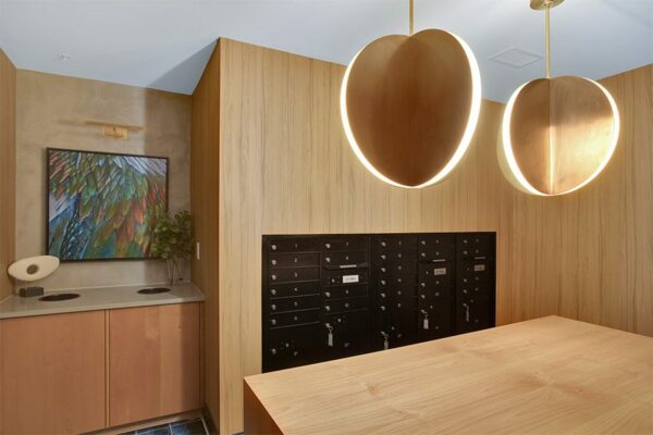 Mail room with pattern tile, wood wall panels, large light fixtures, and mailboxes.