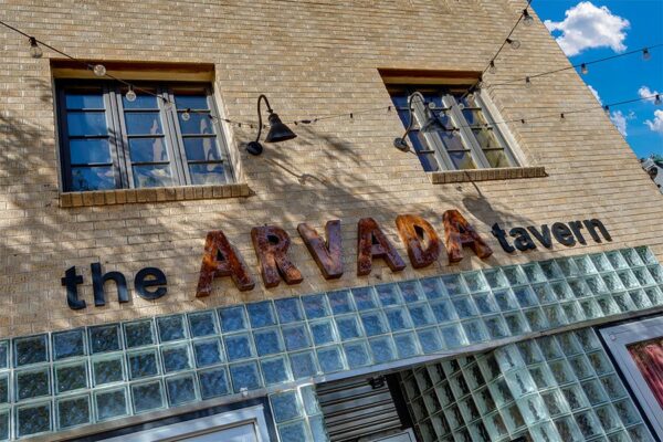 The Arvada Tavern building with glass and blonde brick construction.