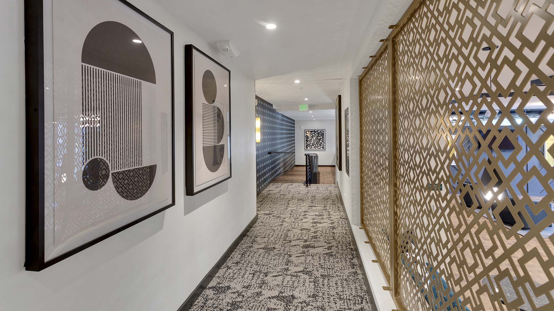 Hallway with carpet, decorative paneling, and geometric modern artwork.