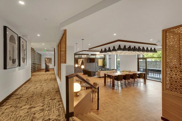 Lounge area with modern furniture, decorative wood paneling, and large windows with natural light.