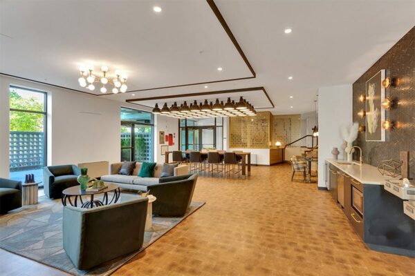 Lounge with end grain wood floor, plush modern furniture, eclectic lighting fixtures, and large windows.