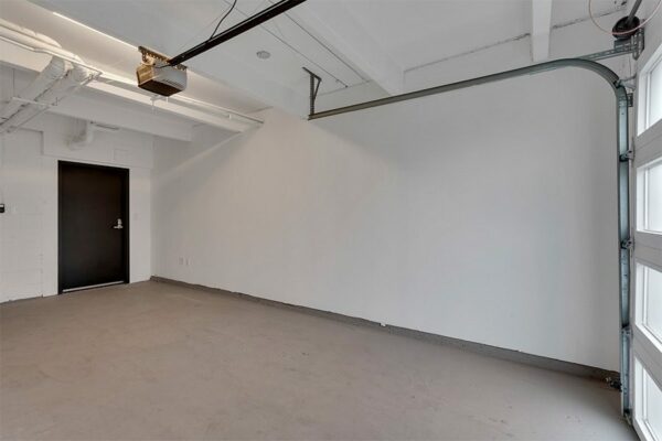 Garage with overhead door and door to unit.
