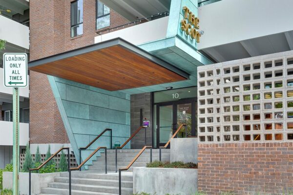 Entrance to the Scot apartments with modern updates and metal monument sign.
