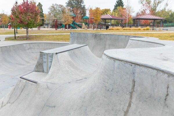 Park with concrete skate park, play equipment, and gazebos.
