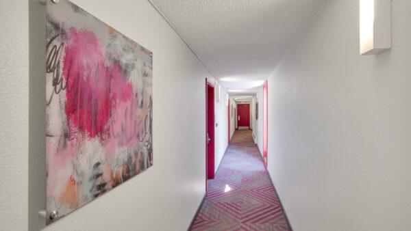 hallways with pink doors and pink carpet