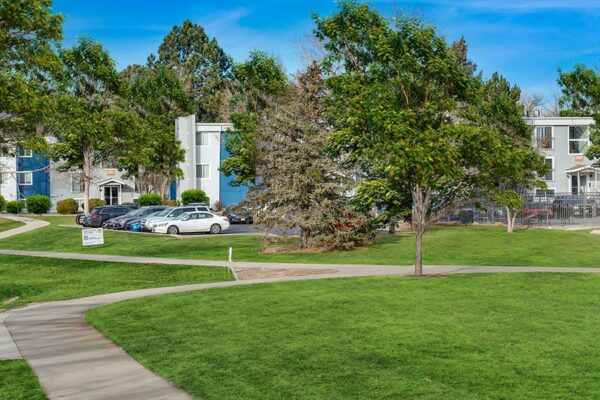 Exterior of The Flats of Creekside with trees, grass, and sidewalks.