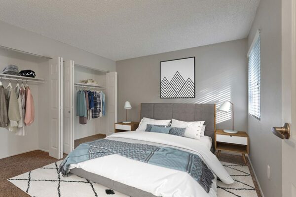 Bedroom with pattern rug, plush bed, artwork, and double closet.