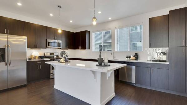 Rendering of a kitchen with a large island, dark wood cabinets, and white countertops.