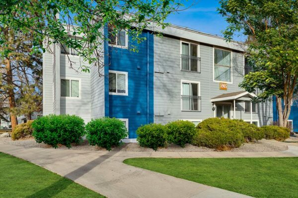 Exterior view of apartments at The Flats at Creekside with shrubbery and sidewalks.