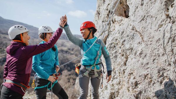 Friends celebrating together while rock climbing.