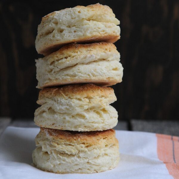 Stack of buttermilk biscuits on cloth napkin.