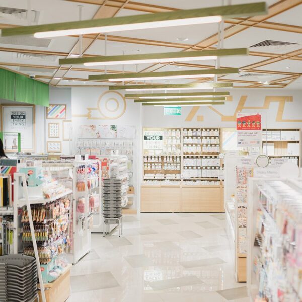 Brightly lit pharmacy with rows of shelving stocked with products.