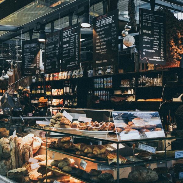 Bakery with large cases of baked goods and chalkboard menus.