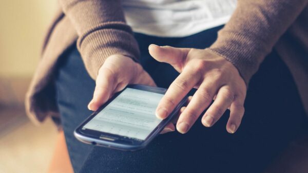 Person sitting down using their smart phone.