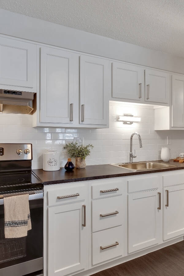 renovated-kitchen-with-white-cabinets-white-tile-backsplash-and-stainless-steele-appliances