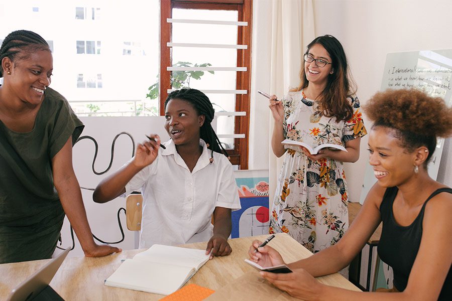 People in office with notebooks and whiteboards.