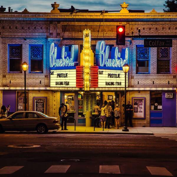 Bluebird Theater in Denver with glowing marquee signage and line of patrons.