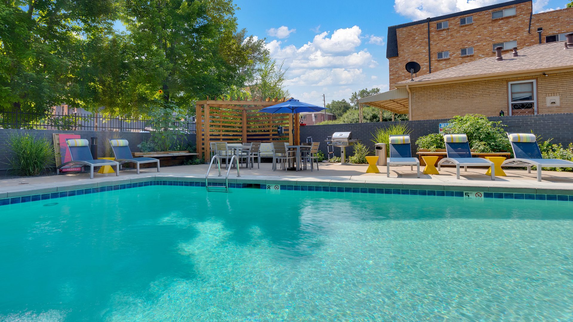 pool at 833 dexter with lounge chairs and grill station