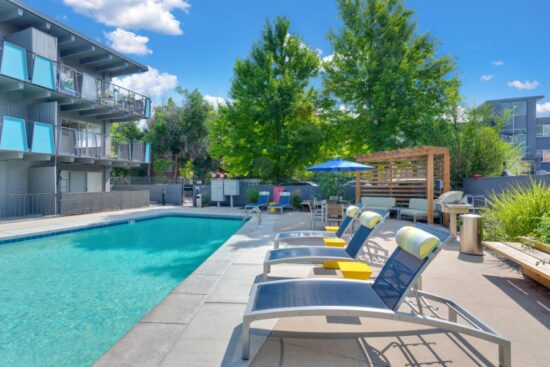 pool with two lawn chairs and grill station