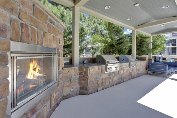 Outdoor lounge with built in BBQ grills, fireplace, and lounge chairs.