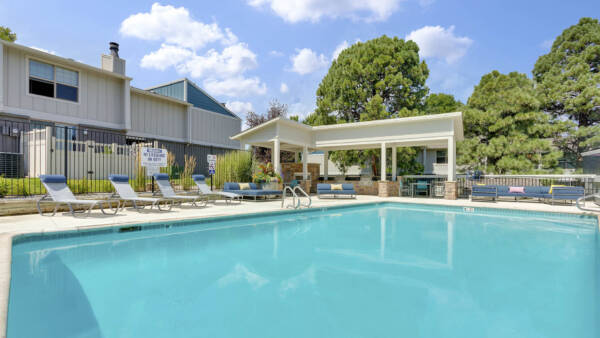 The Pines at Pinehurst pool area with comfortable lounge chairs and shady gazebo.