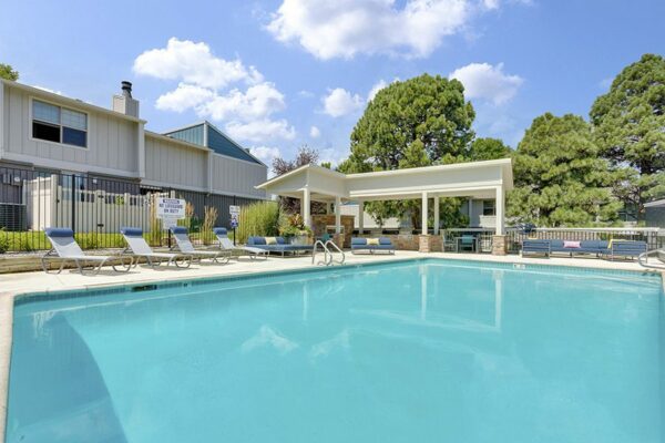 The Pines at Pinehurst pool area with comfortable lounge chairs and shady gazebo.