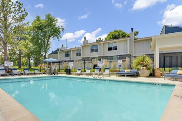 The Pines at Pinehurst pool area with comfortable lounge chairs and shady gazebo.