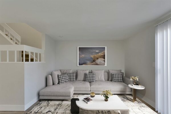 Living room with a plush gray couch and white walls.