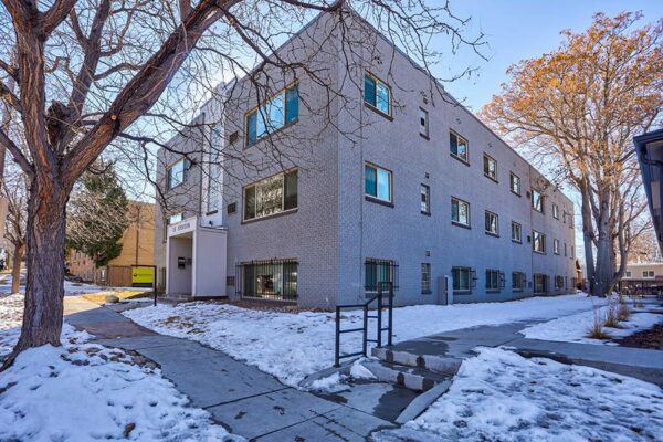 25 Emerson with grey brick construction, tall trees, and classic mid century style.