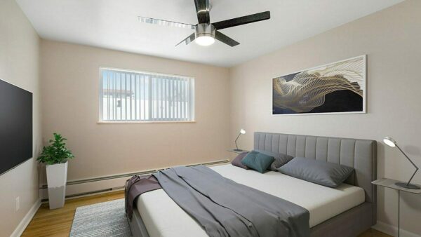 Bedroom with wood floor, rug, plush bed, modern bedside tables with lamps, and ceiling fan.
